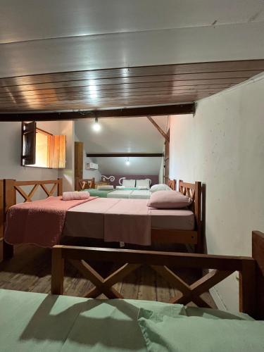two beds are in a room with at POUSADA IPIRÃTÃ - Turismo de Vivência Cultural in Soure