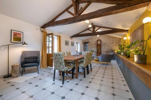 ein Esszimmer mit einem Holztisch und Stühlen in der Unterkunft Gîtes de la Bernière in Brûlain