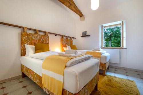 ein Schlafzimmer mit zwei Betten und einem Fenster in der Unterkunft Gîtes de la Bernière in Brûlain