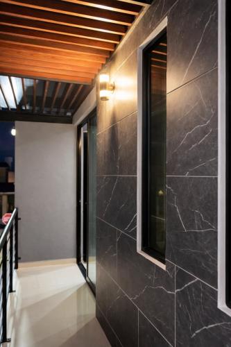 een gang met zwarte marmeren muren en een plafond bij Minimalist City Suite in Chetumal