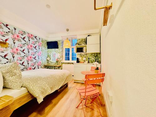 a bedroom with a bed and a table and a kitchen at RB Portobello in London