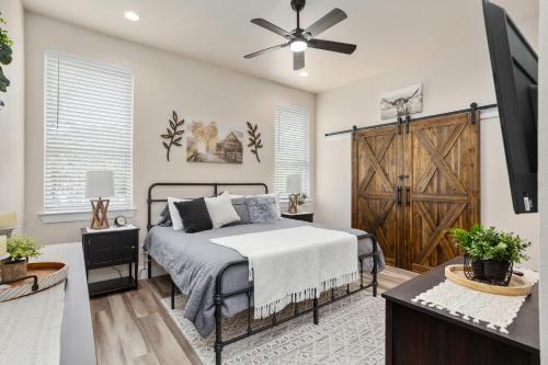 ein Schlafzimmer mit einem Bett und einer Holztür in der Unterkunft Riverscape Townhome A, Just Steps Gruene Hall in Gruene