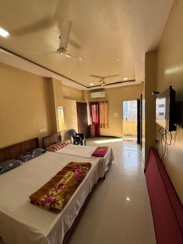 una camera da letto con due letti e una TV a schermo piatto di Hotel parbramha a Pandharpur
