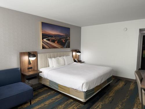 a hotel room with a bed and a blue chair at La Quinta by Wyndham Seattle Sea-Tac Airport in SeaTac