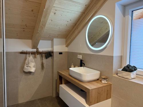 une salle de bains avec un lavabo et un miroir dans l'établissement amKampl-Ferienwohnung, à Radling