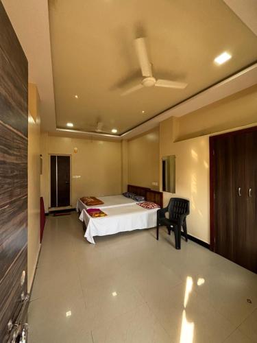 una camera da letto con un letto e una sedia di Hotel parbramha a Pandharpur