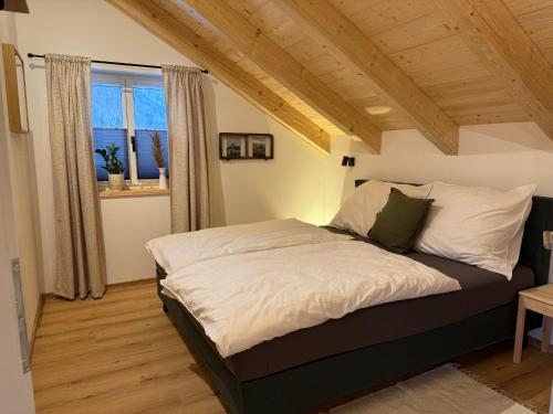 a bed in a room with a large window at amKampl-Ferienwohnung in Radling