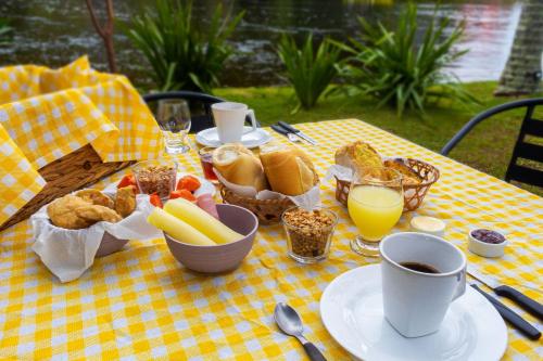 a table with breakfast food on a yellow checkered table cloth at Pousada Quinta da Margem in Florianópolis