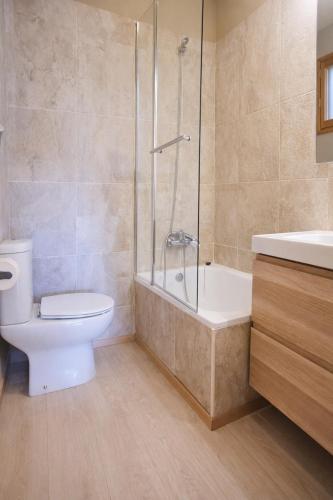 a bathroom with a toilet and a shower and a sink at CaL QuEROL Llivia 2 piscina, 8 pax, 2 baños y parking in Llivia
