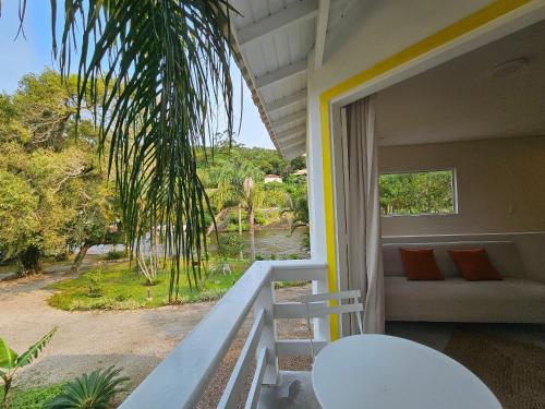 a balcony of a house with a couch and a palm tree at Pousada Quinta da Margem in Florianópolis
