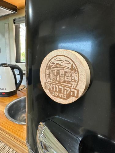 a sticker on the side of a black coffee mug at הקרוואן במושב in Beʼerotayim
