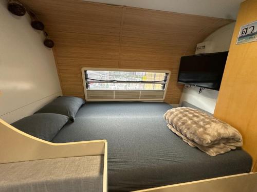 a small room with a bed in a trailer at הקרוואן במושב in Beʼerotayim