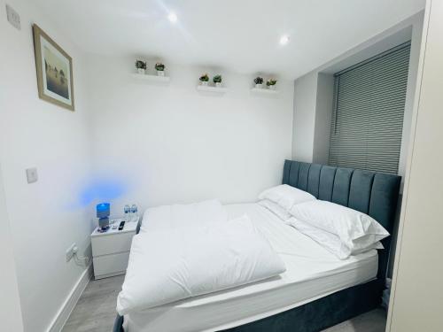 a white bed with a blue headboard in a bedroom at Letza House - Private En-Suite Rooms near Cardiff City Centre in Cardiff