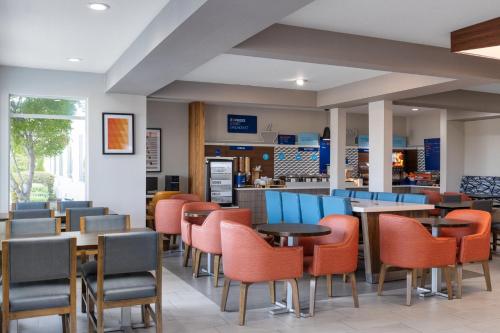 a restaurant with tables and chairs and a counter at Holiday Inn Express Redding North by IHG in Redding