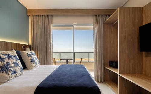 ein Schlafzimmer mit einem Bett und Meerblick in der Unterkunft Wyndham Natal Pitangui Praia in Extremóz