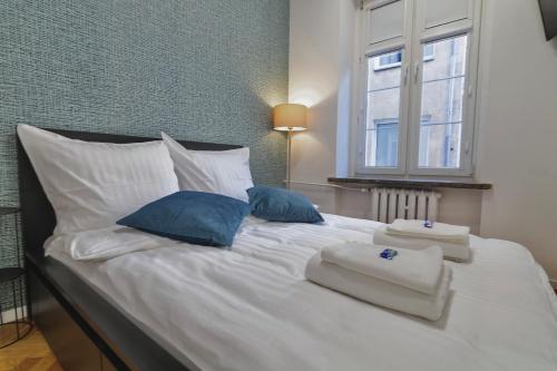 a white bed with two pillows and a window at MonjAna Premium Rynek in Wrocław