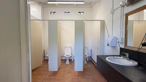 een badkamer met 2 wastafels en een toilet. bij Mt Aspiring Holiday Park in Wanaka