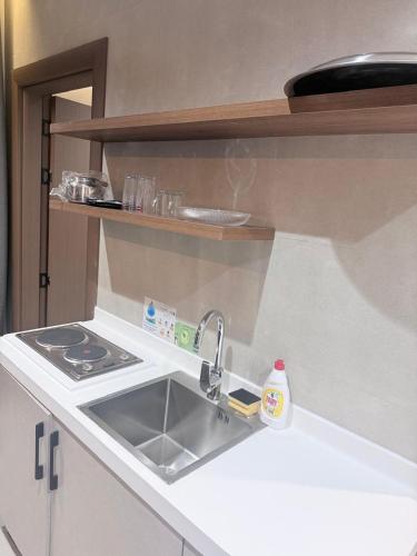 een keuken met een spoelbak en een fornuis bij ديار الاسترخاء للشقق المخدومة in Najran