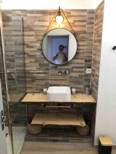a man taking a picture of a bathroom with a mirror at LES BATTERIES bord de mer in Collioure