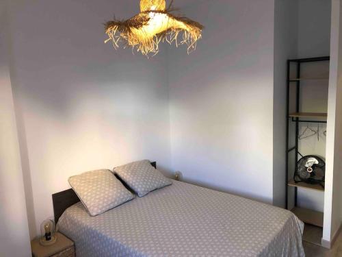 a bedroom with a bed and a chandelier at LES BATTERIES bord de mer in Collioure