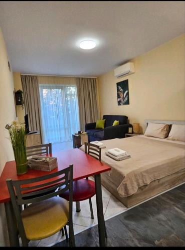 a bedroom with a bed and a table and a couch at One room apartment 112 Аll-season в Св св Константин и Елена in Varna City
