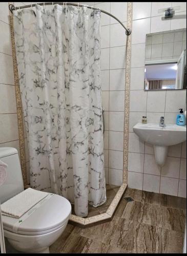 a bathroom with a toilet and a sink and a shower curtain at One room apartment 112 Аll-season в Св св Константин и Елена in Varna City