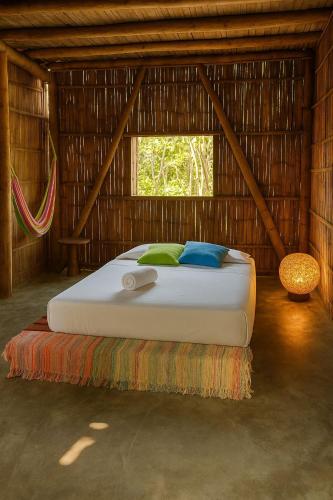 a bedroom with a bed in a straw hut at Glamping Due Amici Restobar in Palomino