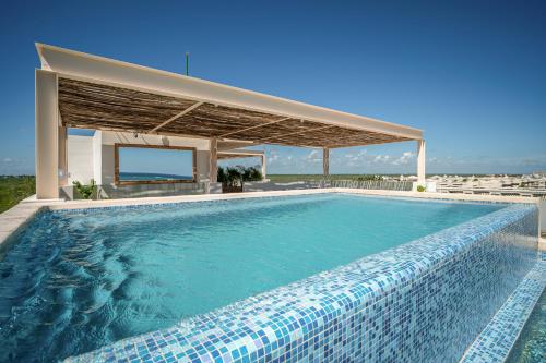 a swimming pool with a pavilion and a swimming poolvisor at Greta Puerto Morelos - By Aloja RV in Puerto Morelos