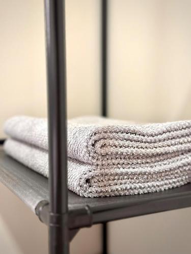 een stapel handdoeken op een metalen plank bij Apartamento Palmeira Essencial in Formosa