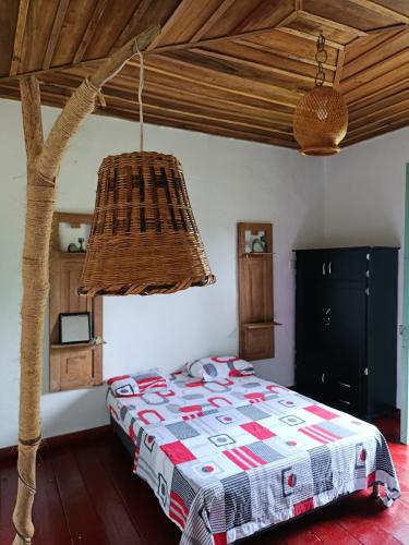 ein Schlafzimmer mit einem Bett und einem Kronleuchter in der Unterkunft Koniminto in Pijao