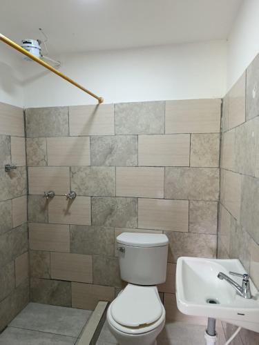 ein Badezimmer mit Toilette und Waschbecken in der Unterkunft Koniminto in Pijao