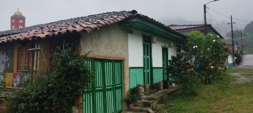 een groen en wit huis met een poort bij Koniminto in Pijao