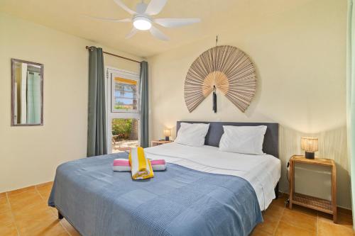 a bedroom with a large bed with a ceiling fan at Maravia Bonaire in Kralendijk