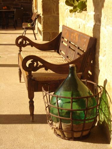 a bench with a green glass vase in a basket at Pazo a Capitana in Cambados