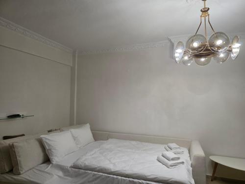 a bedroom with a bed with white sheets and a chandelier at Searea House in Perea