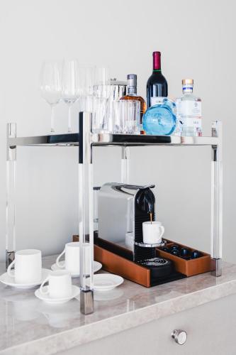 a shelf with cups and a coffee maker on it at Surf & Sand Laguna Beach in Laguna Beach