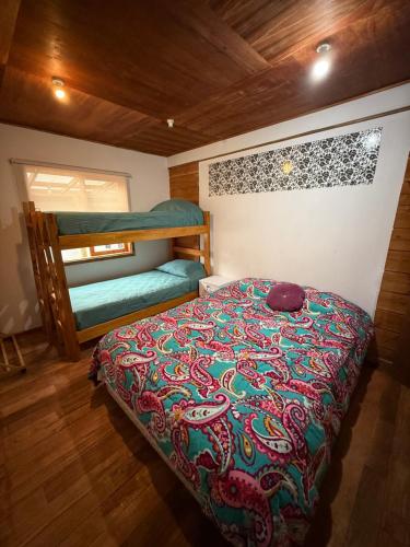 a bedroom with a bed and bunk beds at Hostal Route 5 in Pucón