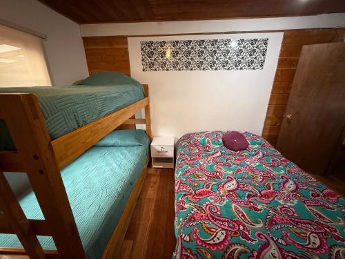 a small room with a bunk bed and a bed sidx sidx sidx at Hostal Route 5 in Pucón