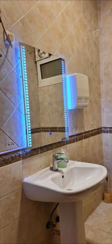 a bathroom with a sink and a mirror at Sharif Apartments in Medina