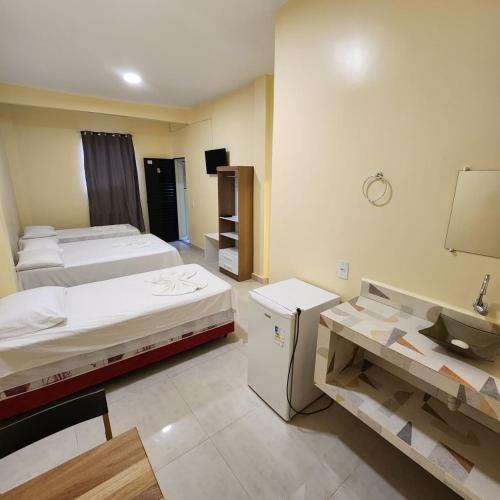 una camera con due letti e un lavandino in esso di Hotel Rocha a Barcarena