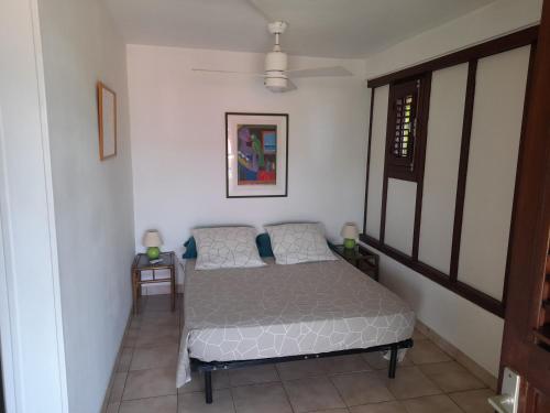 a small bedroom with a bed in a room at chez Brigitte et Michel in Les Anses-dʼArlets