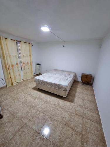 a white room with a bed and a dresser in it at El Solar in San Antonio Oeste