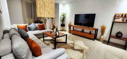 ein Wohnzimmer mit Sofa und Flachbildfernseher in der Unterkunft Happiness Apartment in Ouarzazate