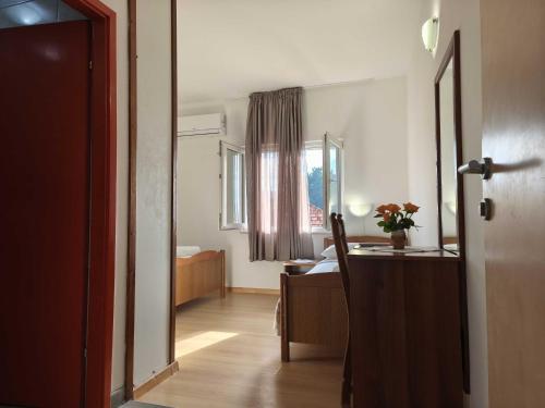 a room with a desk and a bed and a window at Pansion Danilo by the sea in Krmčina