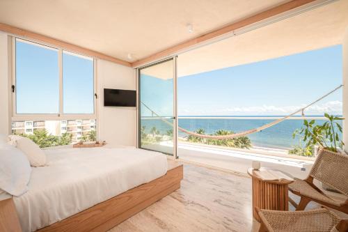 a bedroom with a large window with a view of the ocean at Greta Puerto Morelos - By Aloja RV in Puerto Morelos