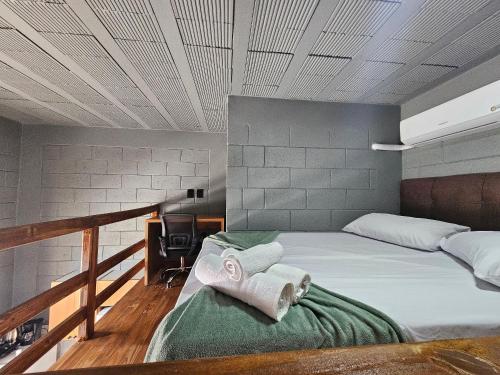 a bedroom with two towels sitting on a bed at Residencial Zille - Lofts e Studios in São Miguel dʼOeste