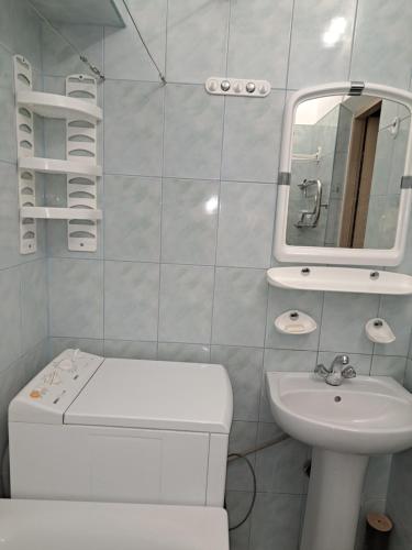 a white bathroom with a sink and a mirror at Квартира Шевченка in Lutsk