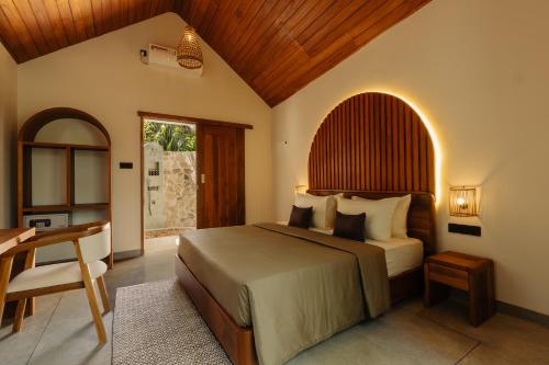 a bedroom with a bed with a wooden ceiling at The Benison in Ahangama