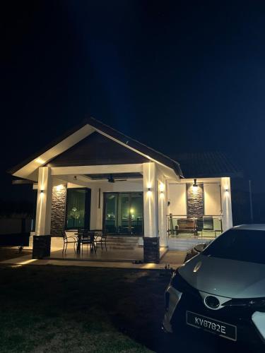 een wit huis met 's nachts verlichting bij Villa PW 3 Bedrooms in Langkawi Intl
