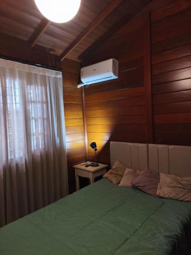 een slaapkamer met een groen bed en een plafondventilator bij Quarto com cama de casal - Florianópolis in Florianópolis